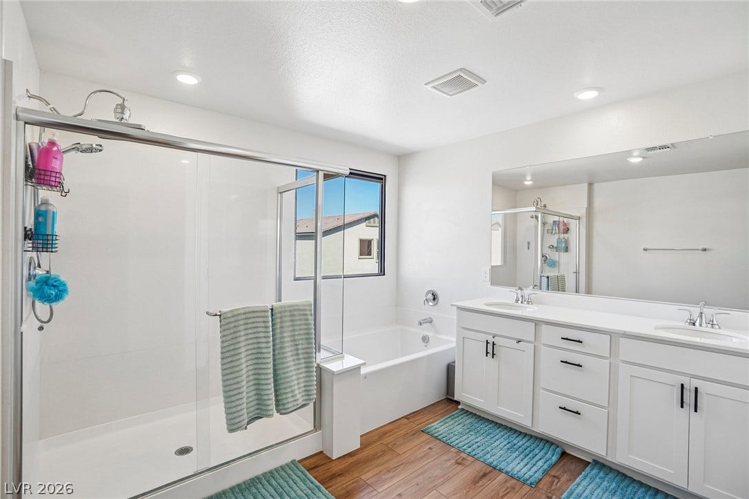 5937 Violet Crown Street, North Las Vegas, NV 89081 Plank flooring runs beneath a double vanity, soaking tub, and walk-in glass shower enclosure.