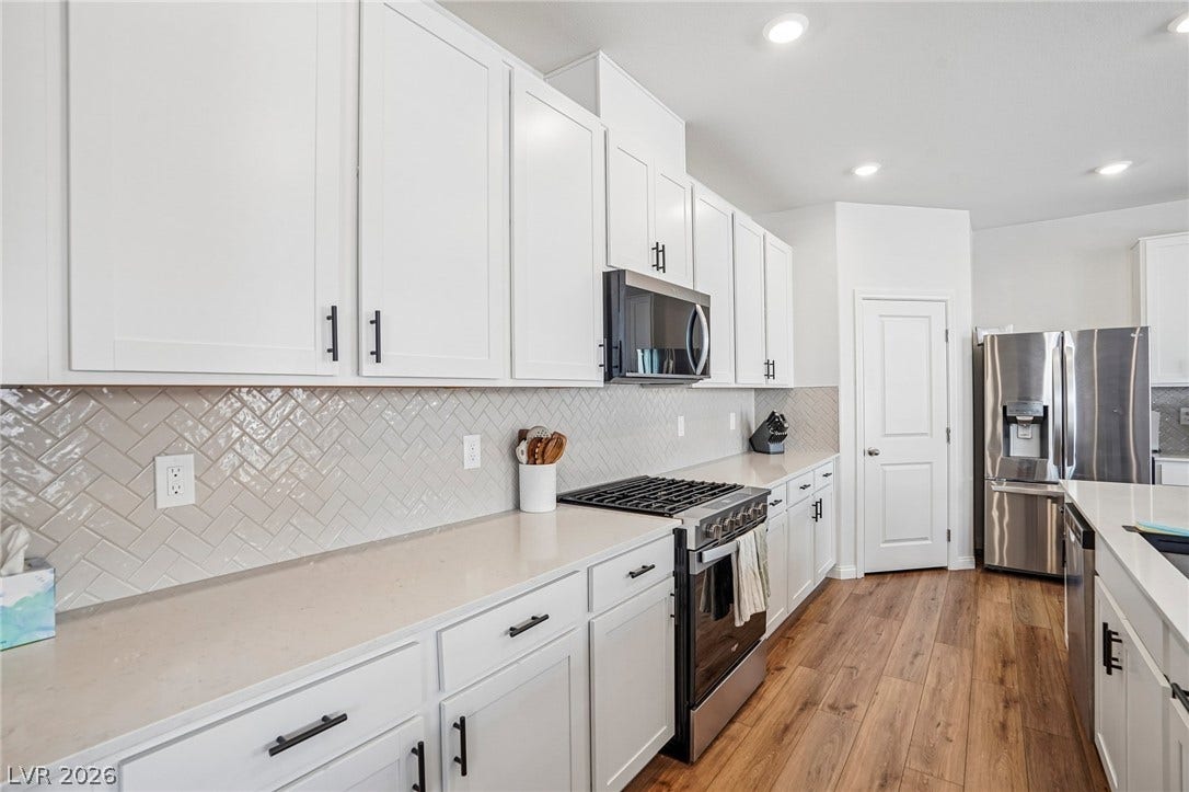 5937 Violet Crown Street, North Las Vegas, NV 89081 Modern cabinetry and solid surface countertops complement the recessed lighting and durable wood flooring.