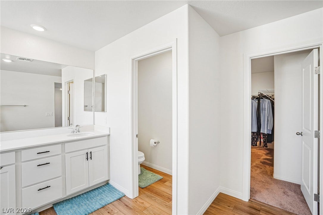5937 Violet Crown Street, North Las Vegas, NV 89081 Sleek vanity cabinetry anchors this functional bathroom layout complete with an adjacent walk-in closet.