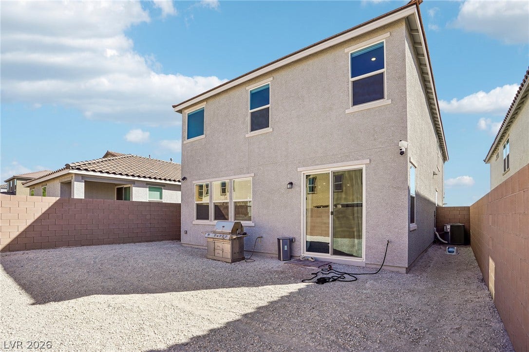 5937 Violet Crown Street, North Las Vegas, NV 89081 An enclosed backyard area features low-maintenance gravel landscaping and a stucco exterior.