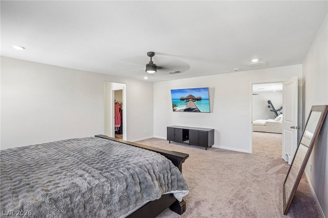 5937 Violet Crown Street, North Las Vegas, NV 89081 Plush carpeting anchors this spacious bedroom featuring clean lines and a functional layout.