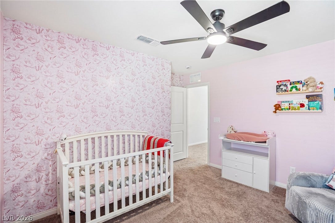 5937 Violet Crown Street, North Las Vegas, NV 89081 Plush carpeting anchors this charming nursery workspace with clean baseboards and classic drywall finishes.