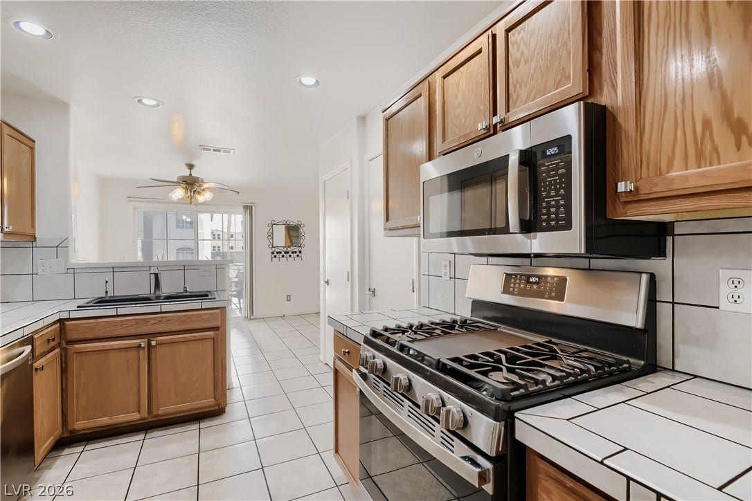 Gleaming tile floors and warm wood cabinetry define this functional kitchen workspace.