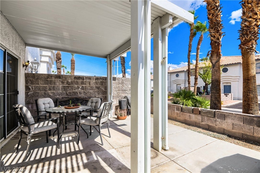 A covered concrete patio provides an ideal space for outdoor relaxation and entertaining.