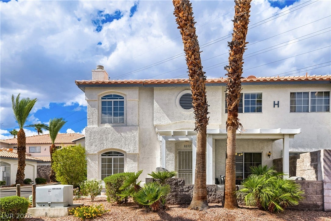 Stucco exterior elements combine with a classic tile roof and manicured desert landscaping.