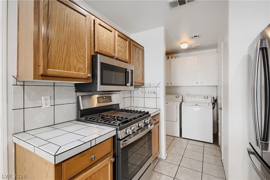 Functional kitchen design opens directly to a convenient laundry area with tile flooring.
