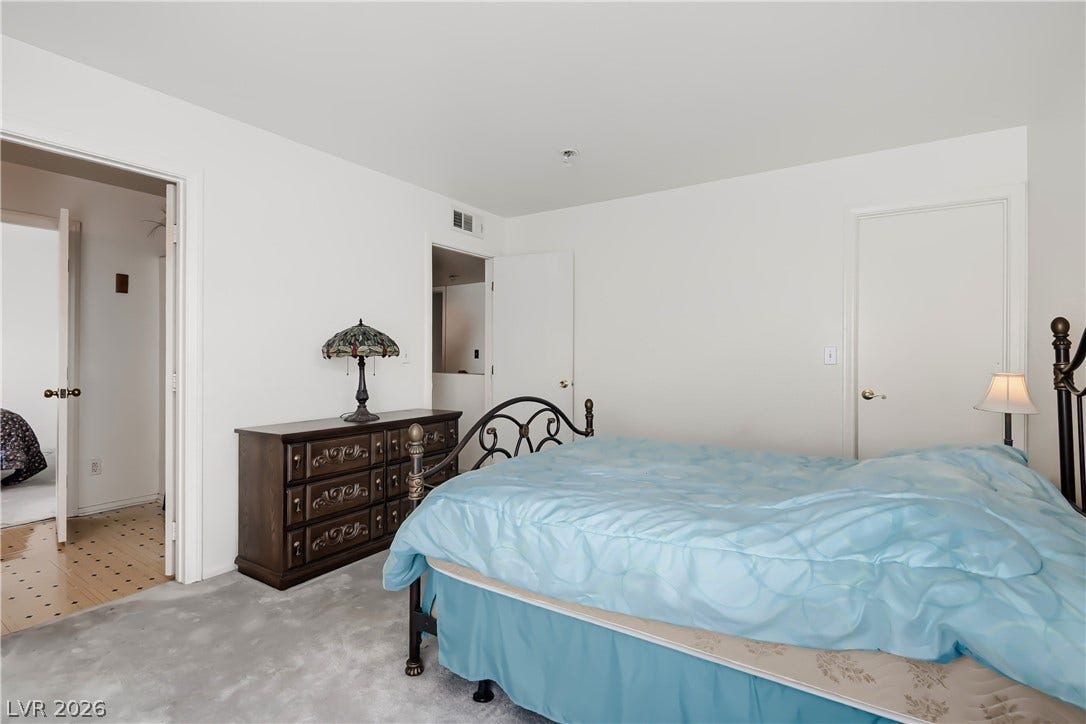 Smooth plaster walls and soft carpeting define this quiet, comfortable sleeping space.