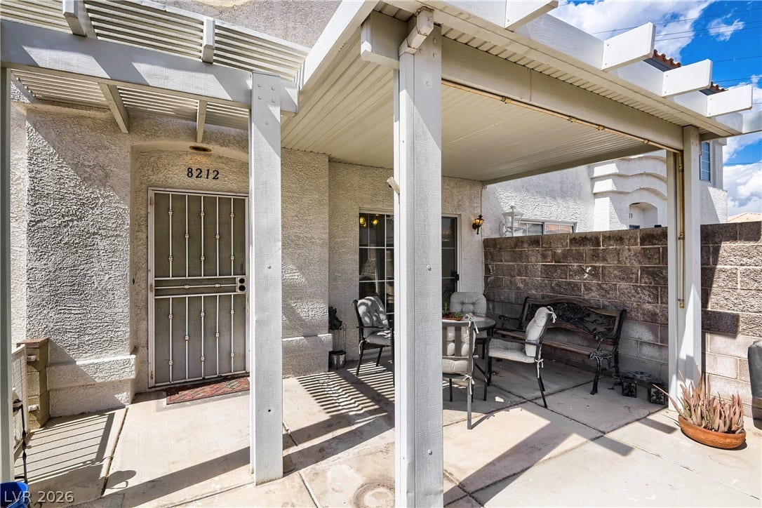 An inviting covered patio offers a private outdoor retreat framed by stucco walls.