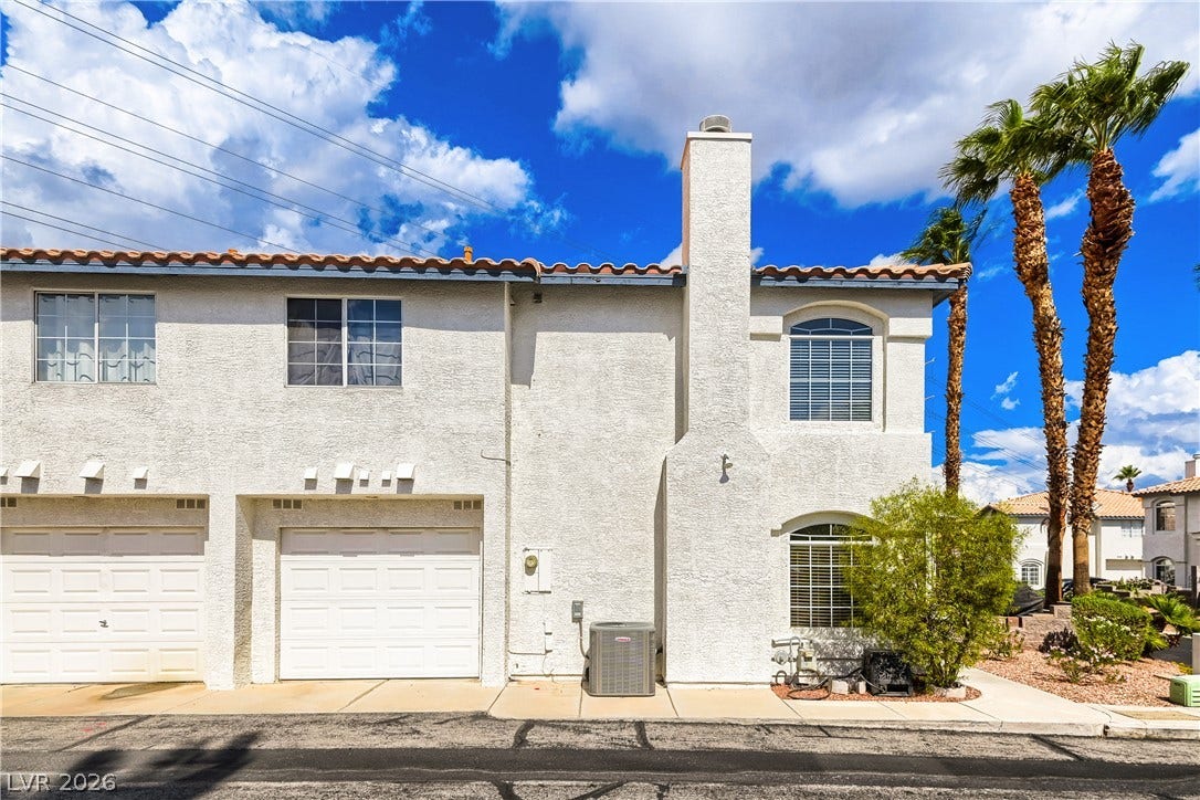 Spanish tile rooflines and stucco siding define this multi-level exterior silhouette under clear blue skies.