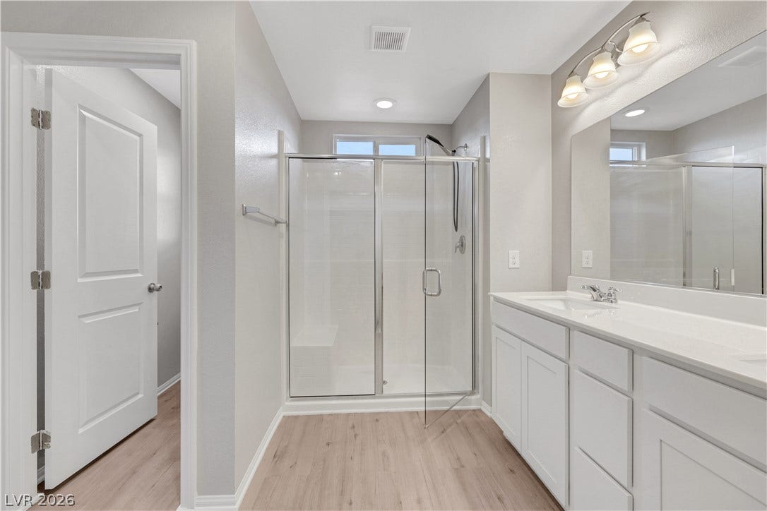 Clean lines and a spacious dual vanity define this modern, light-filled primary bath.