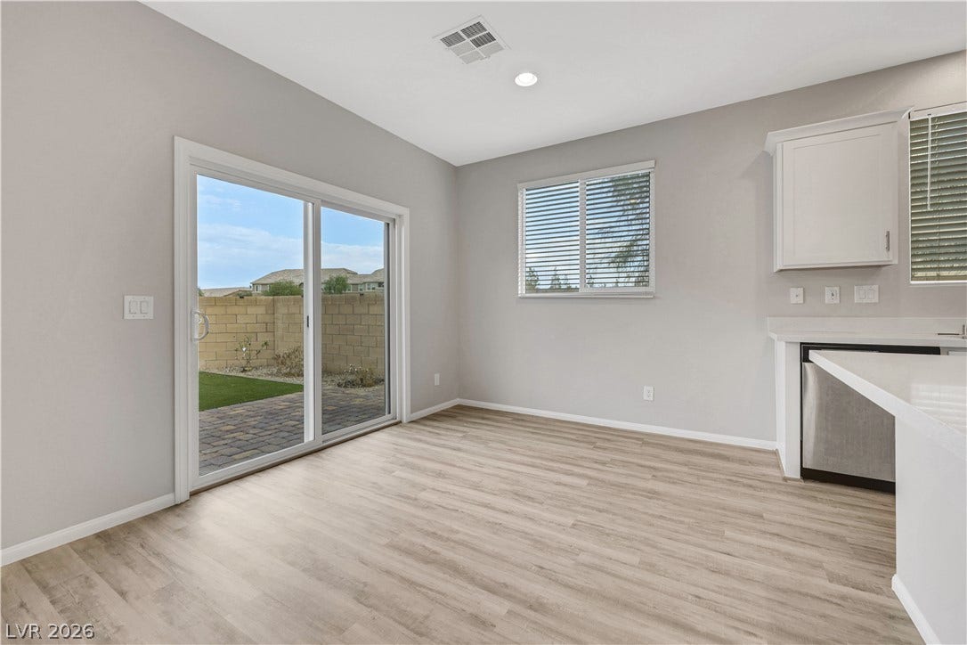 Sliding glass doors open from the casual dining area directly to the paved patio.