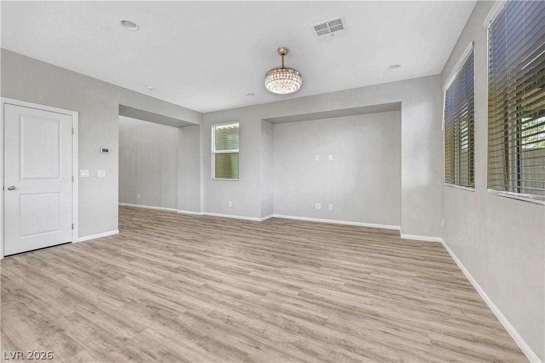 An open living space features durable vinyl plank flooring and a recessed media wall.