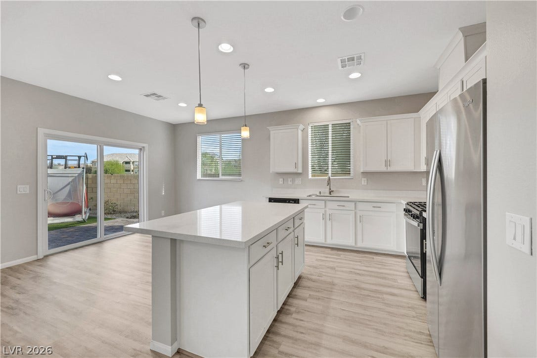 Gleaming quartz countertops and a spacious central island anchor this modern culinary workspace.