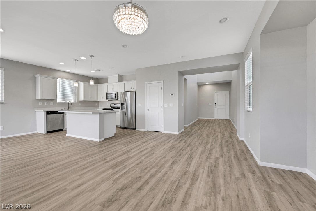 French oak luxury vinyl plank flooring unite the kitchen and main living spaces in this modern layout.