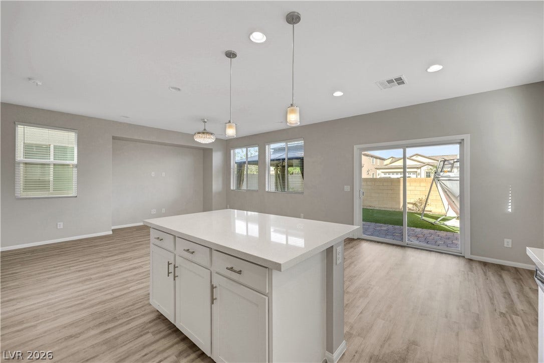 Sliding glass doors open from the kitchen and dining area to the backyard.