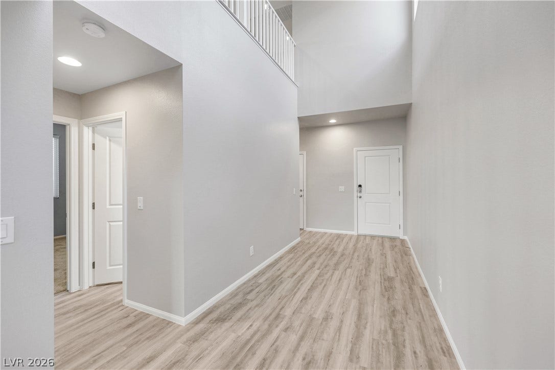 Clean lines and smooth vinyl plank flooring define this soaring entry hall.