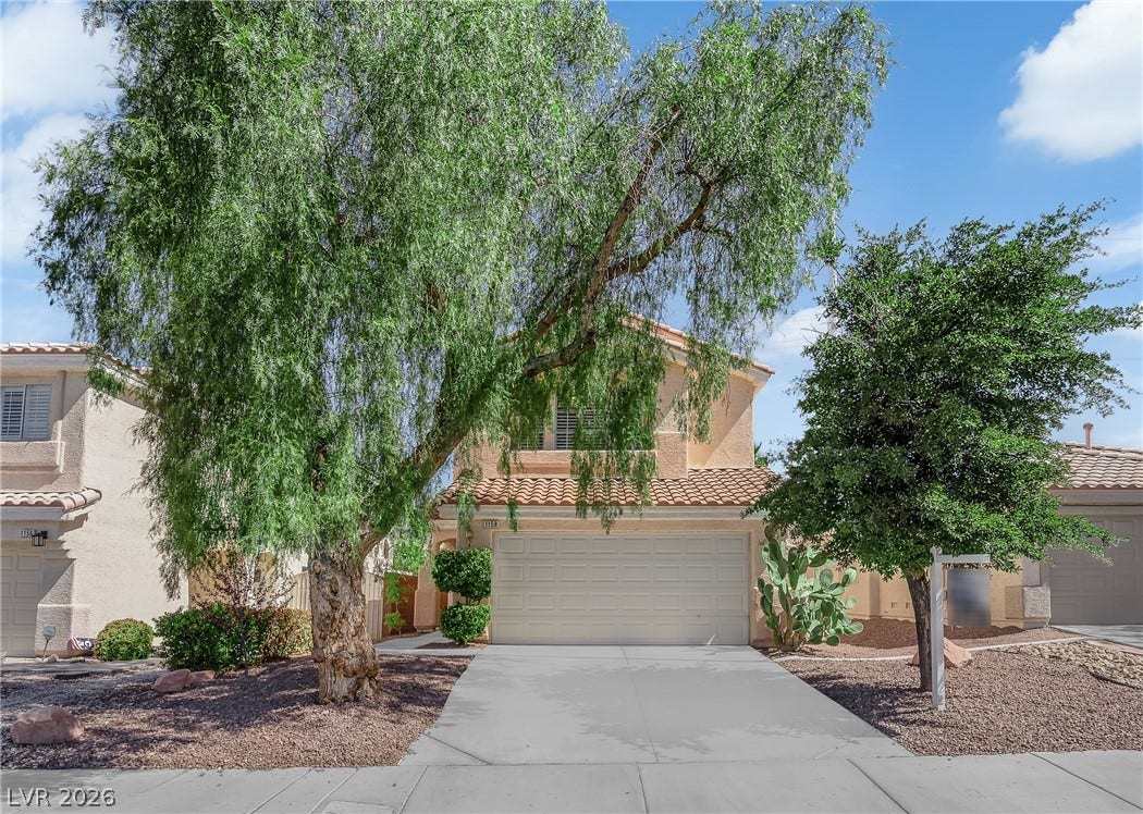 1158 Ekalaka Road, Henderson, NV 89052 Mature trees frame a welcoming facade complete with a tile roof and clean concrete driveway.