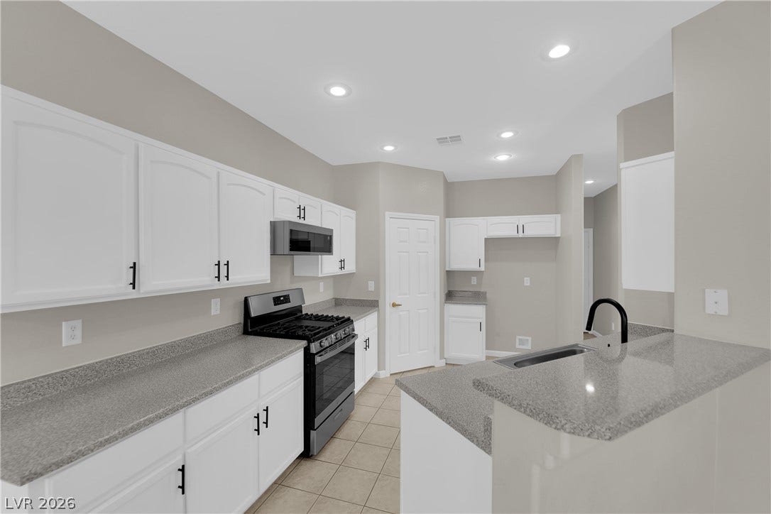 1158 Ekalaka Road, Henderson, NV 89052 Gleaming stone countertops and crisp white cabinetry define this functional, modern cooking space.