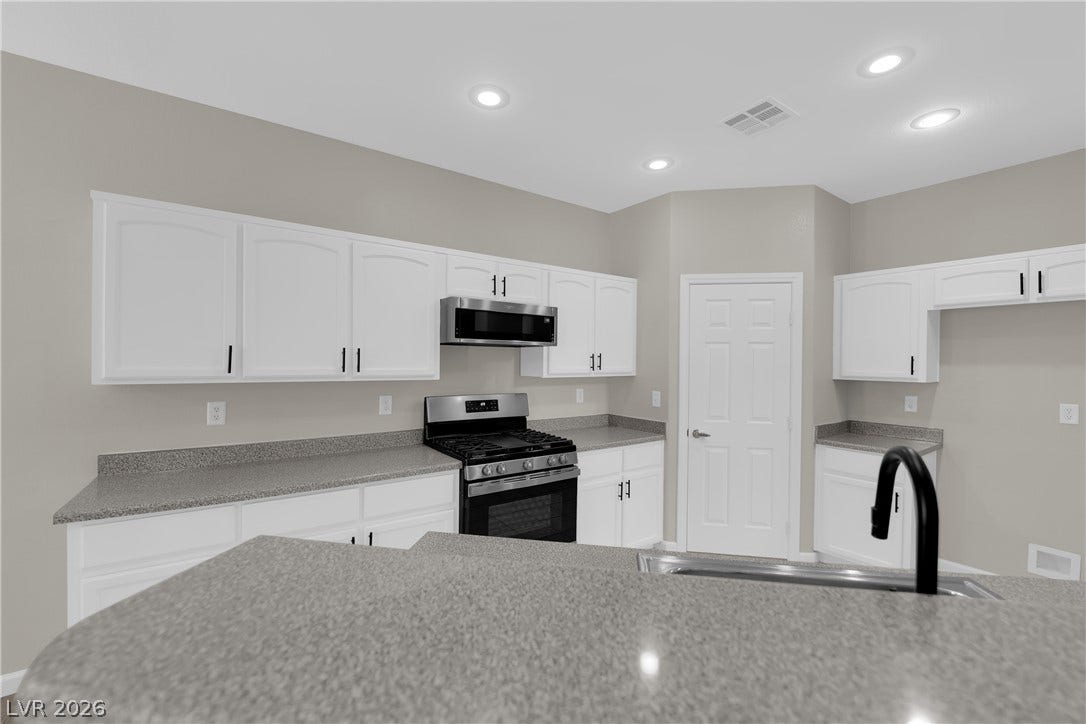 1158 Ekalaka Road, Henderson, NV 89052 Crisp white cabinetry pairs with durable stone counters in this updated kitchen.