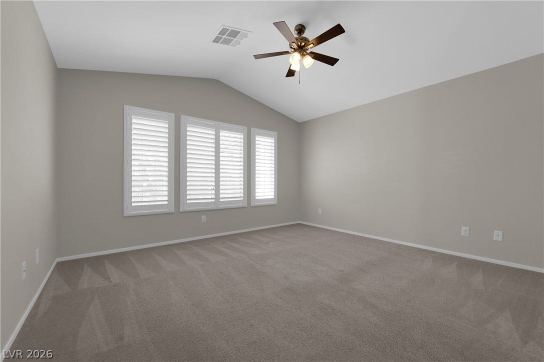 1158 Ekalaka Road, Henderson, NV 89052 Vaulted ceilings and plush carpeting define this versatile living space illuminated by shuttered windows.
