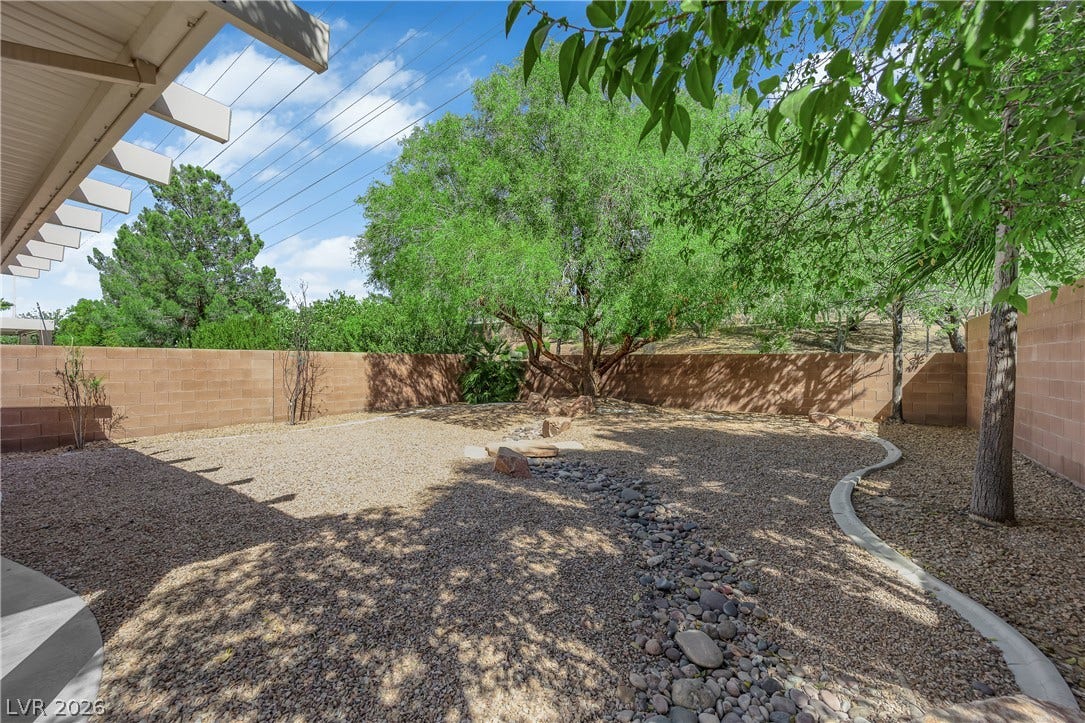 1158 Ekalaka Road, Henderson, NV 89052 Mature trees and low-maintenance desert landscaping define this enclosed outdoor space.