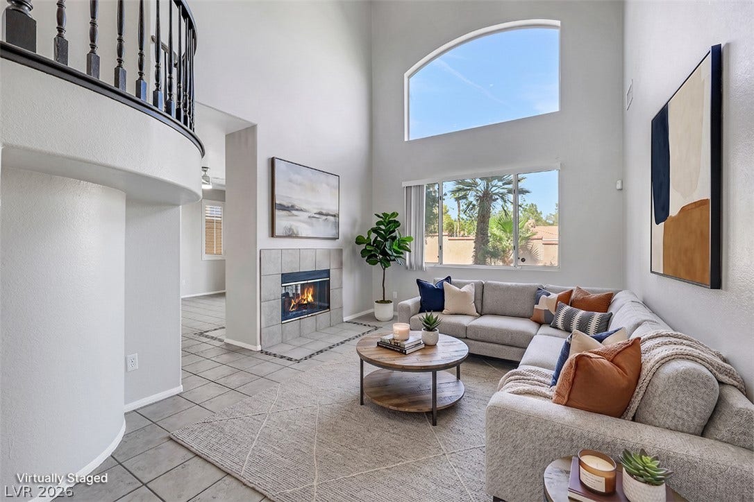Towering ceilings and a classic tile fireplace define this airy living space.