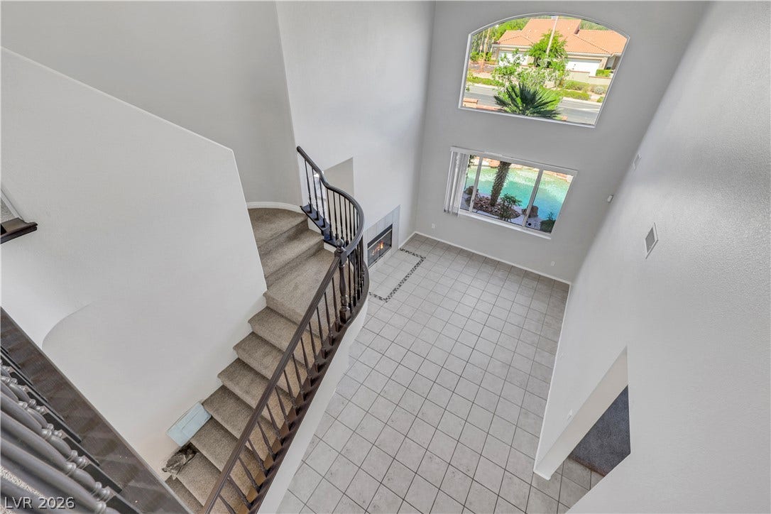 Double-height ceilings and arched windows frame views of the pool from this light-filled room.