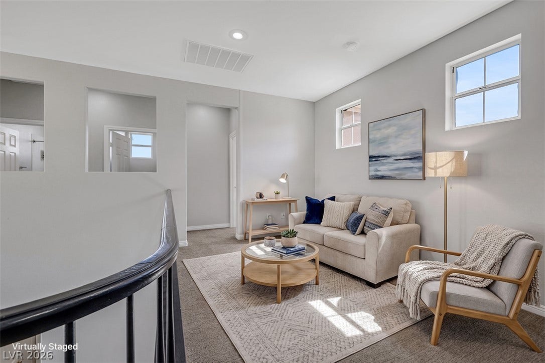 Recessed lighting and wall openings illuminate a carpeted upper-level landing space.