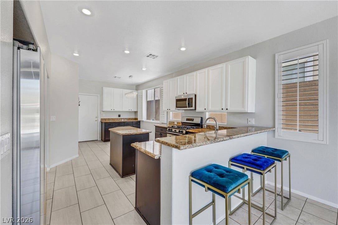 Polished stone countertops and clean tile flooring define this modern culinary space.