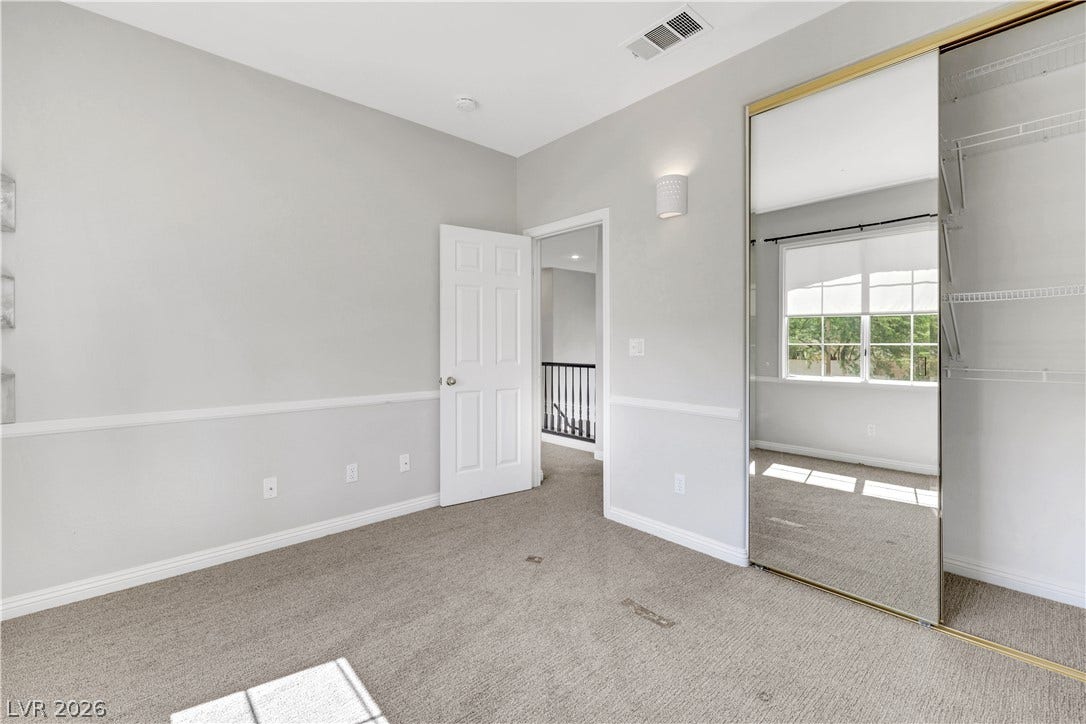 Plush carpeting and elegant chair rail molding define this versatile secondary bedroom space.