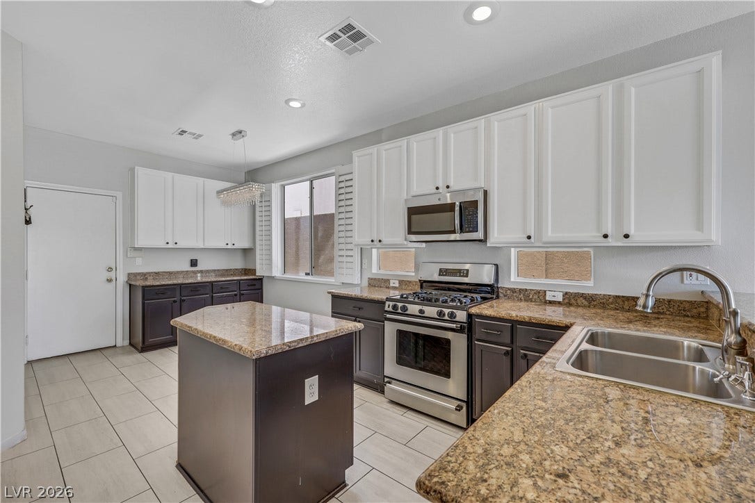 Gleaming stone countertops and matching cabinetry surround a central prep island in this modern kitchen.