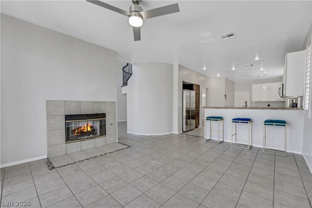 Tiled floors and a cozy fireplace anchor this open-concept main living space.