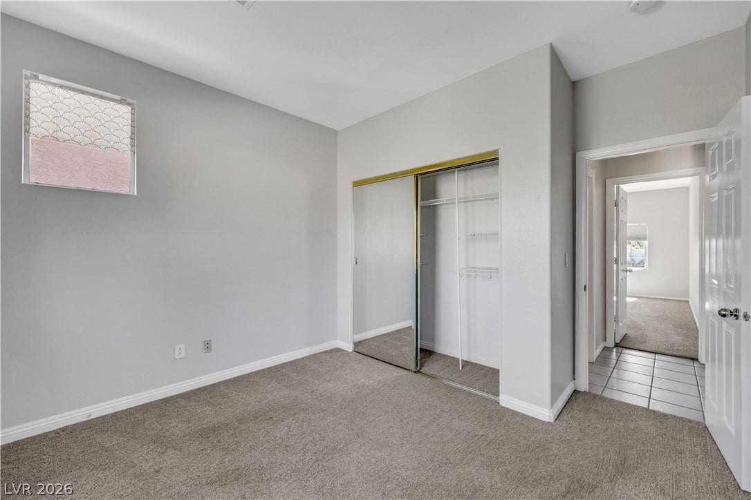 Plush carpeting anchors this peaceful bedroom featuring mirrored sliding closet doors.