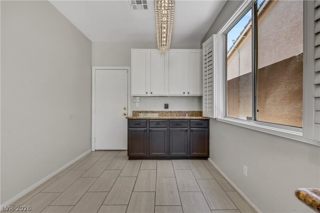 Tiled flooring and granite countertops anchor this versatile bonus area.