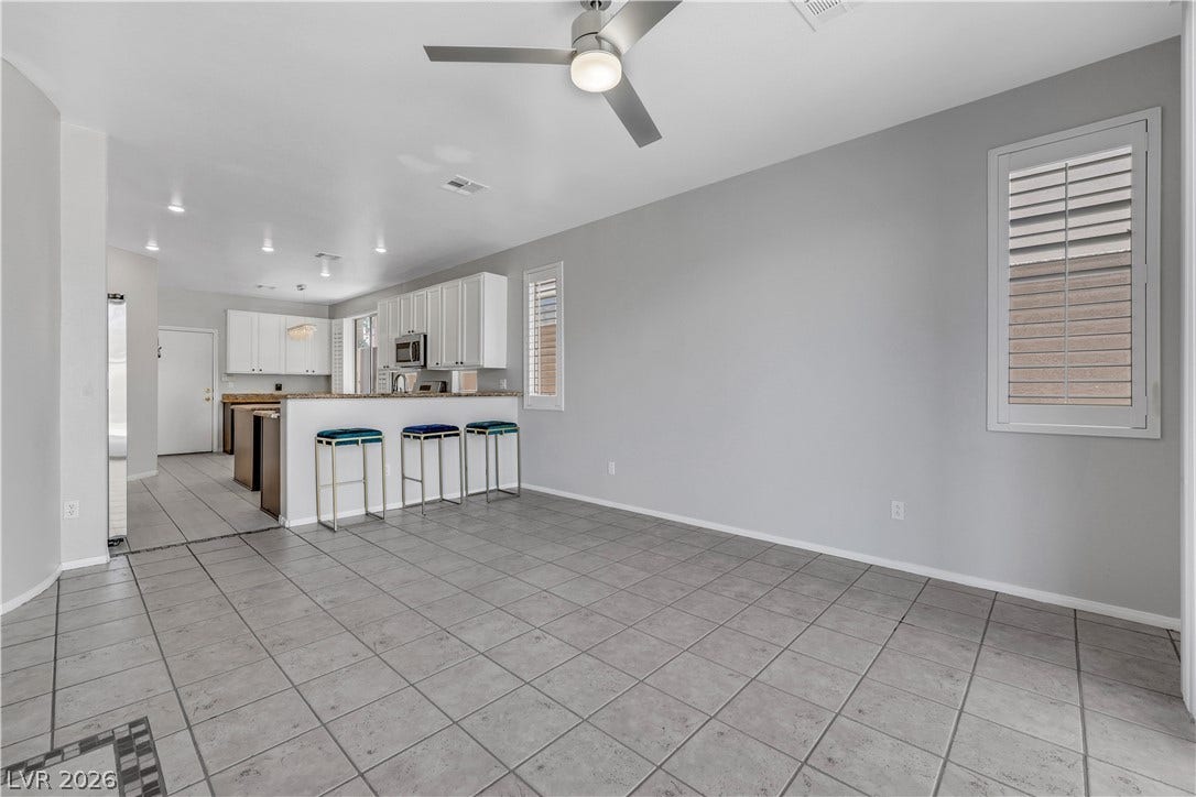 An open layout connects the tiled living space directly to the kitchen bar.