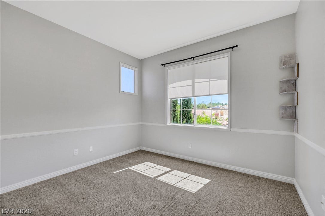 Plentiful natural light streams across the carpeted floor of this versatile upper-level room.