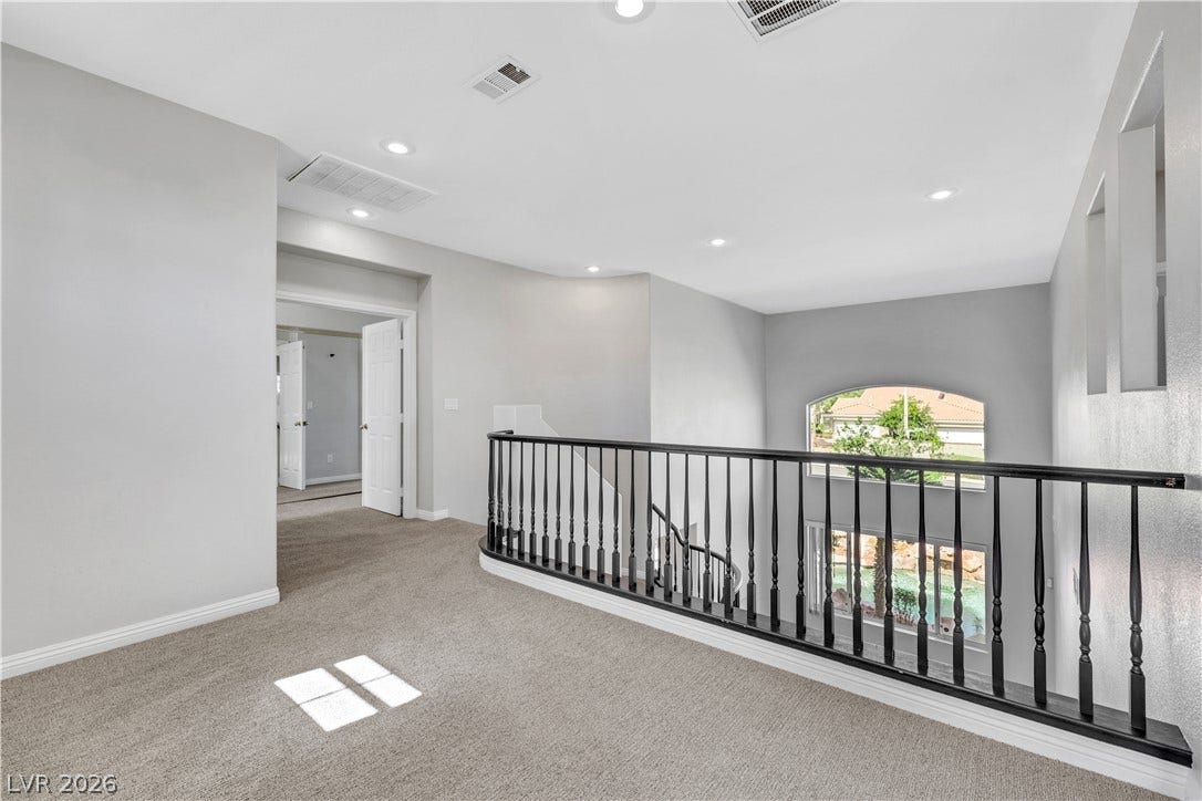 An airy upper-level landing overlooks the lower living space through a classic balustrade.