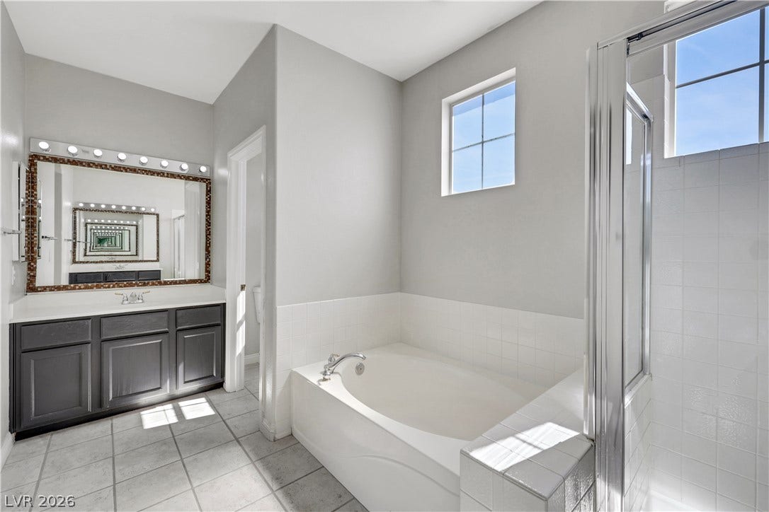 A spacious soaking tub and walk-in shower highlight this tile-floored bathroom layout.