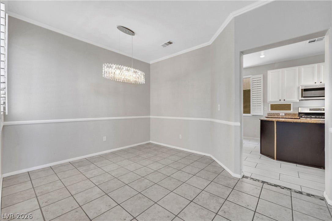 Crown molding and tiled floors define this inviting dining area adjacent to the kitchen.