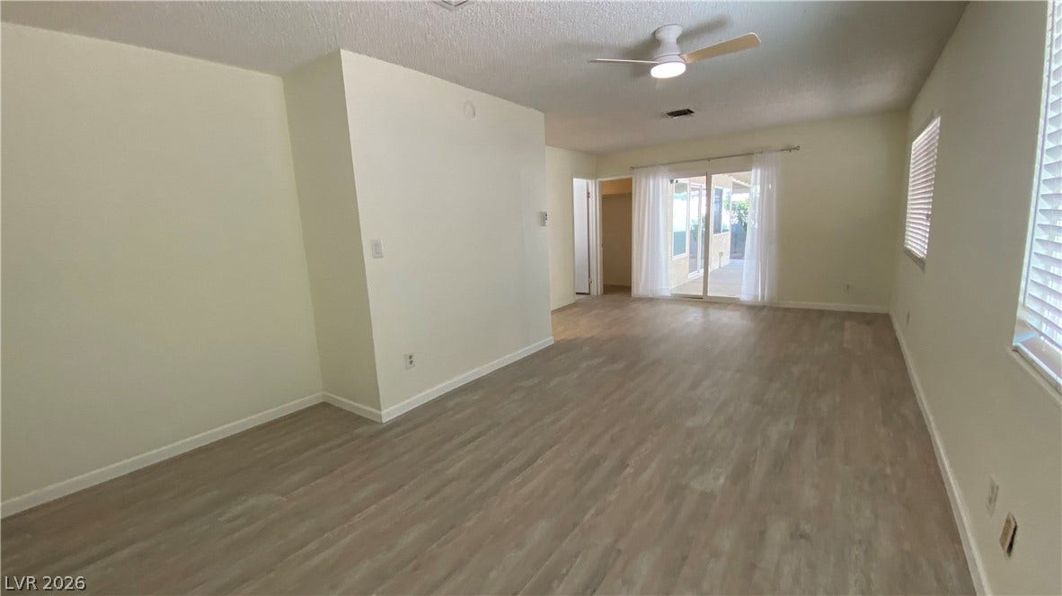 Las Vegas, NV 89119 Smooth wood-look flooring and glass sliding doors define this versatile open living space.