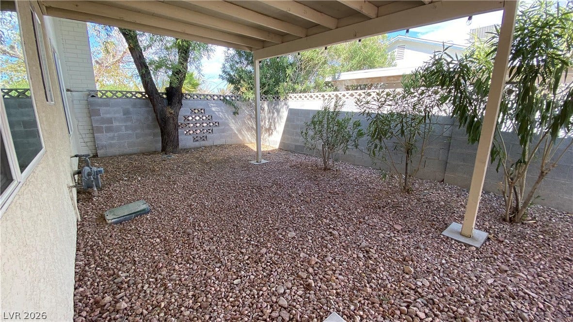 Las Vegas, NV 89119 An enclosed backyard features gravel landscaping, mature plantings, and a sheltered patio area.
