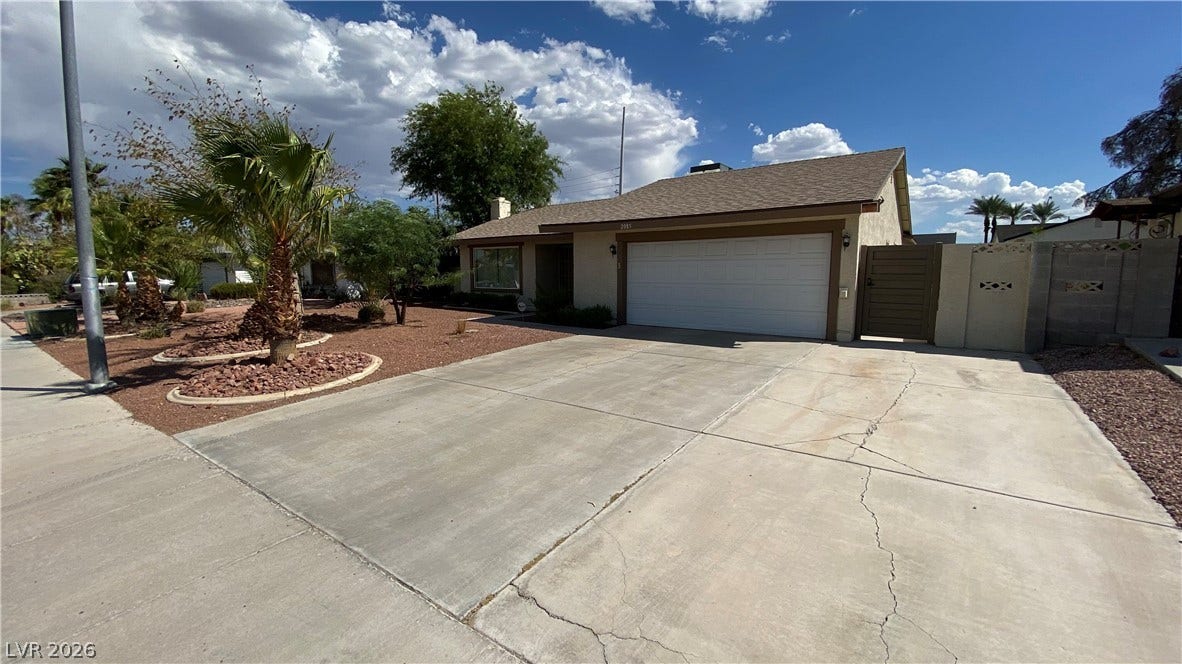 Las Vegas, NV 89119 A spacious concrete driveway leads directly to the attached two-car garage under clear desert skies.