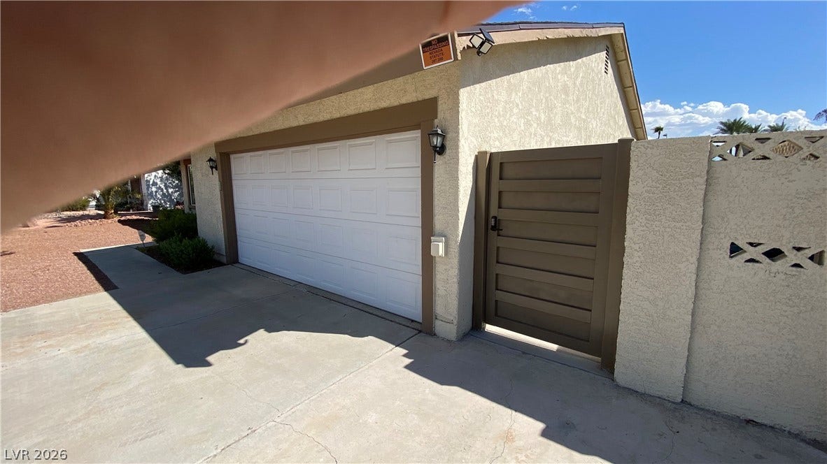 Las Vegas, NV 89119 A spacious concrete driveway leads directly to the attached garage and private gated entry.