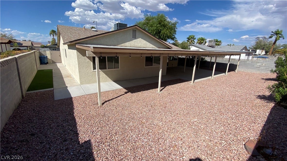 Las Vegas, NV 89119 A spacious covered patio spans the rear facade, overlooking a low-maintenance gravel yard.