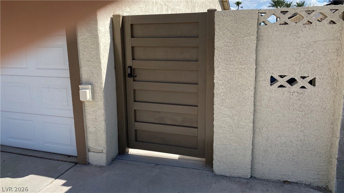 Las Vegas, NV 89119 Secure gated entryway sits framed by textured stucco walls adjacent to the garage.