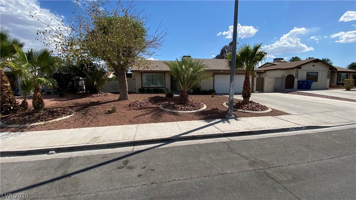 Las Vegas, NV 89119 Palm trees and low-maintenance desert landscaping frame this classic single-story suburban residence.