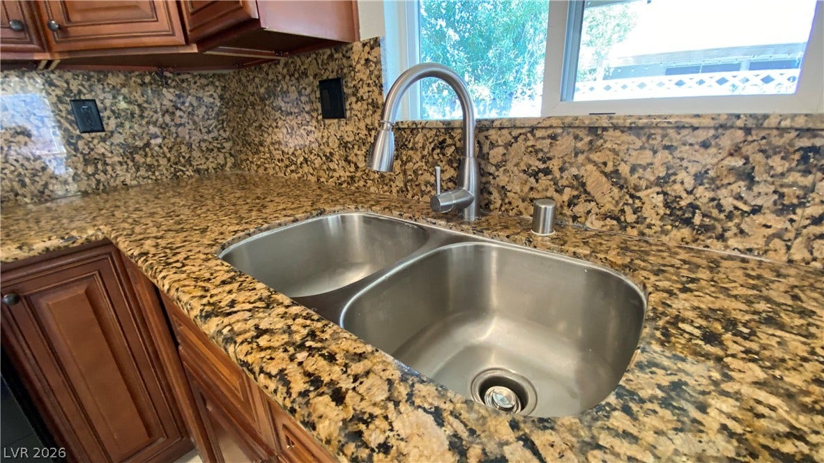 Las Vegas, NV 89119 Richly patterned granite countertops frame a double stainless steel sink beneath a sunny window.