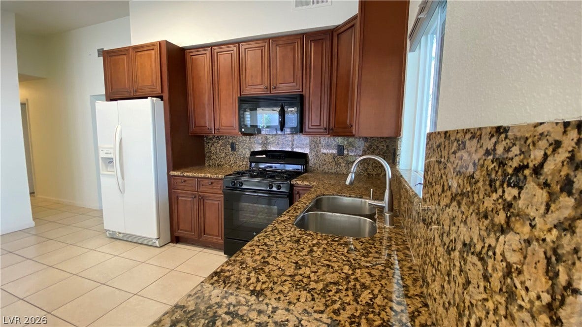 Las Vegas, NV 89119 Granite countertops and warm wood cabinetry define this functional cooking space.