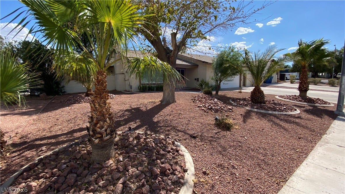 Las Vegas, NV 89119 Palm trees and desert landscaping frame the front exterior of this single-story home.