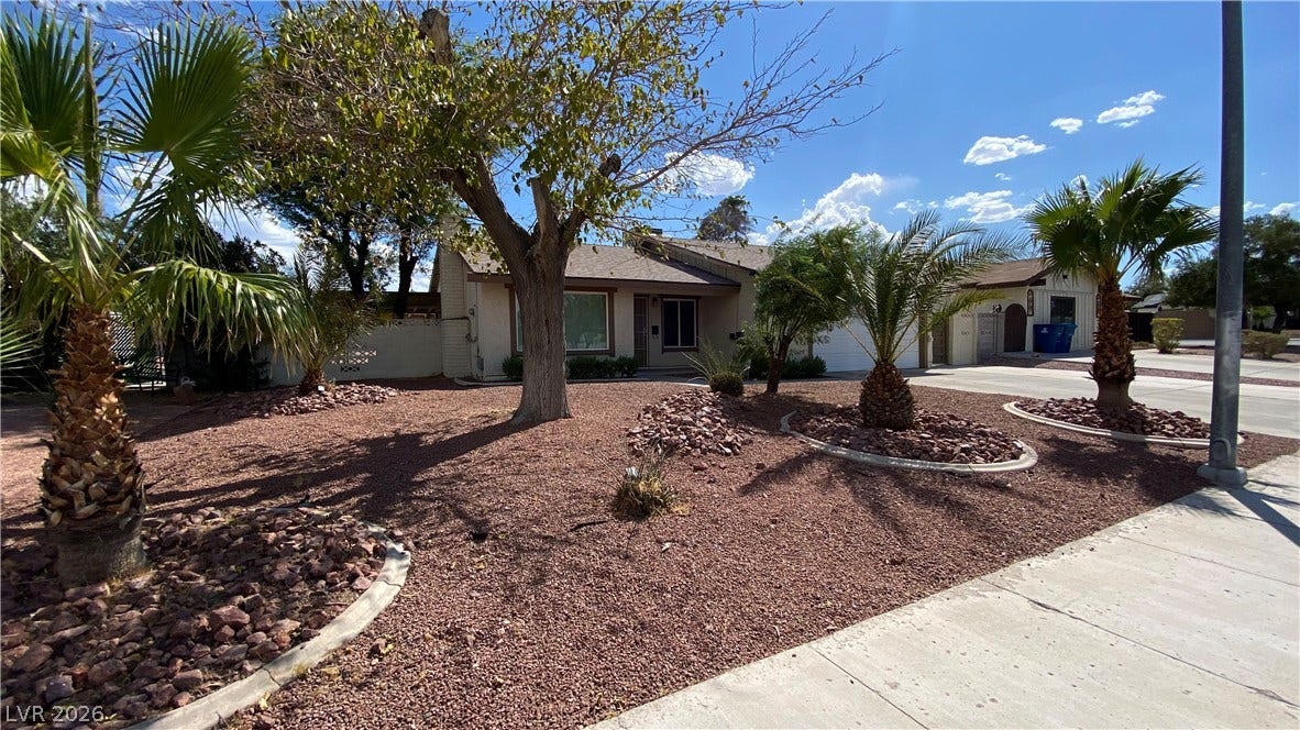 Las Vegas, NV 89119 Mature palms and desert landscaping frame the front yard of this single-story residence.